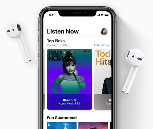 iPhone with AirPods on either side, music artwork on screen.