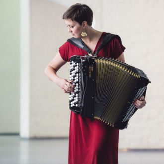 Accordionist Teija Niku plays her accordion in an empty room.