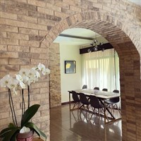 a room filled with furniture and vase of flowers on a brick building