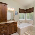 remodeled bathroom with cabinets, tile and tub
