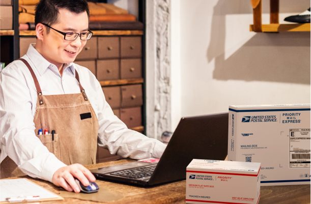 Business owner at a desk preparing to ship Priority Mail boxes.