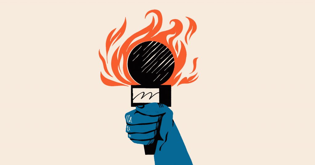 A hand holding a mic which is on fire.