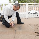 man inspecting a damaged deck