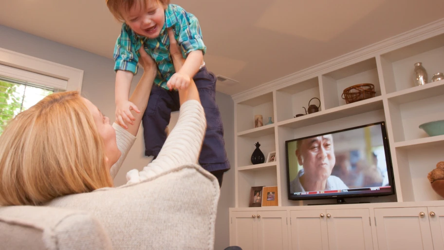 mother and child with a television in the background