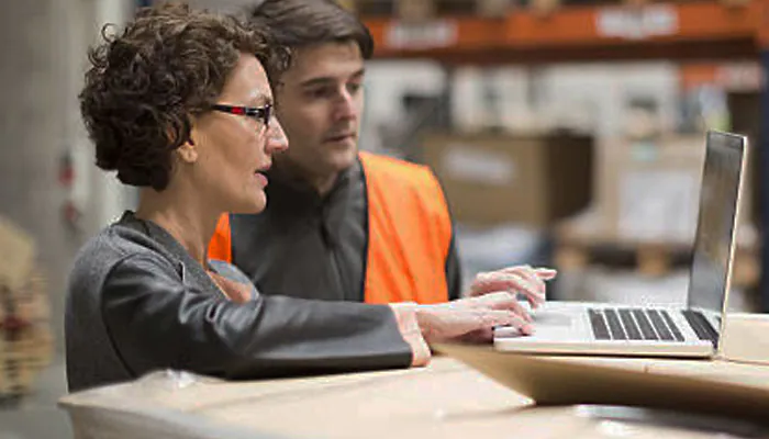 a woman showing a laptop screen to a man