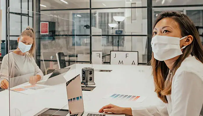 two women taking part in a meeting wearing facemasks