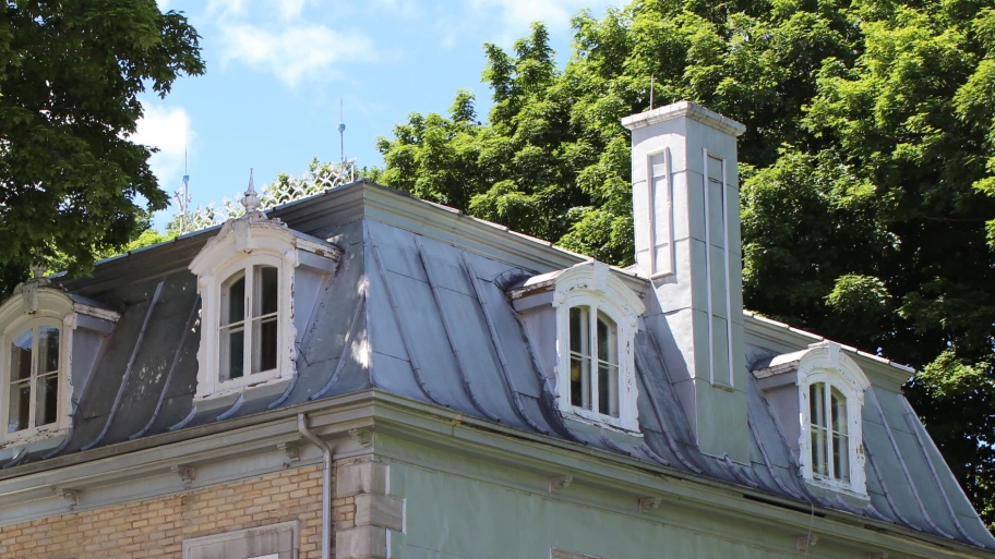 lightning rods atop old home with metal roof