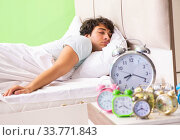 Young man having trouble waking up in early morning. Стоковое фото, фотограф Elnur / Фотобанк Лори