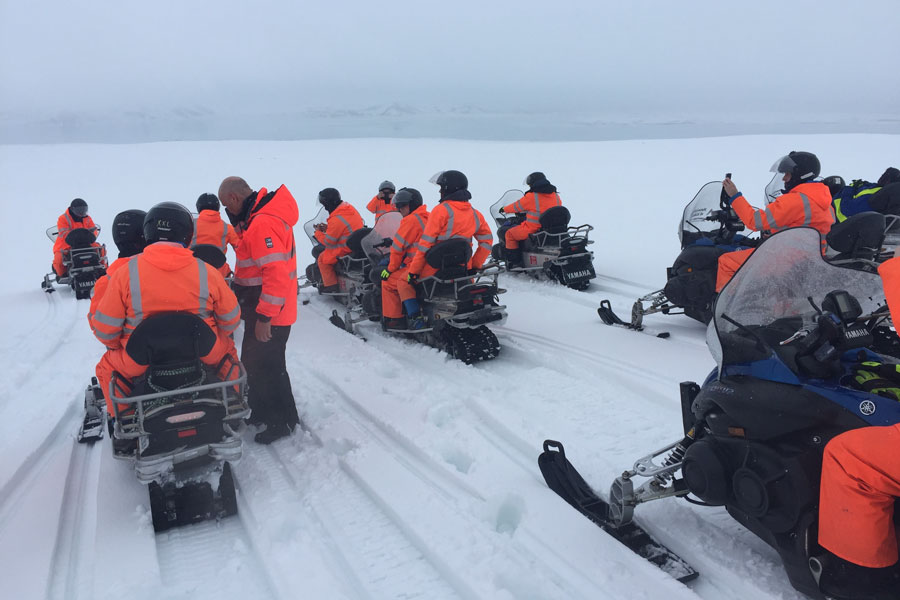 People riding snowmobiles