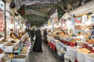 Menn og en kvinne i en basar i Ardabil i Iran. Fra taket henger svarte flagg og bannere med arabisk skrift som markerer sørgemåneden muharram.