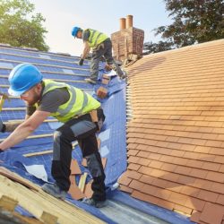 roofers nail down roof matting and tiles