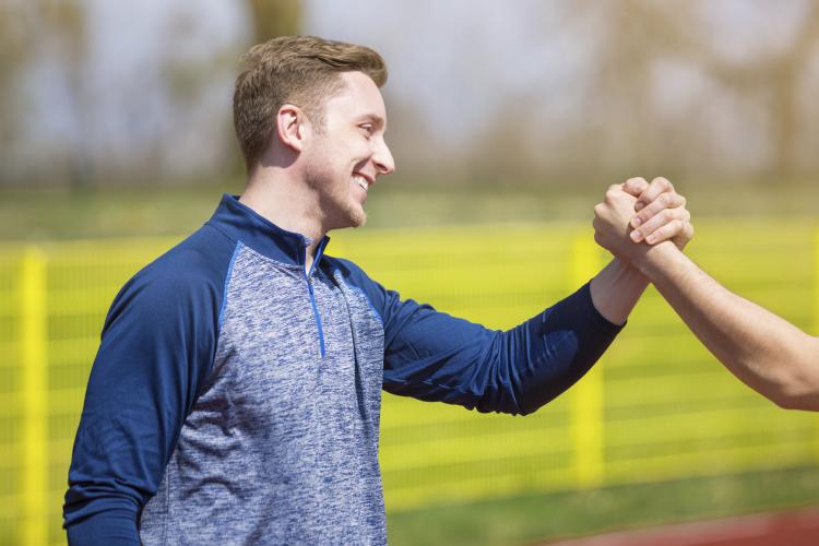 Man getting a complementing hand grab.