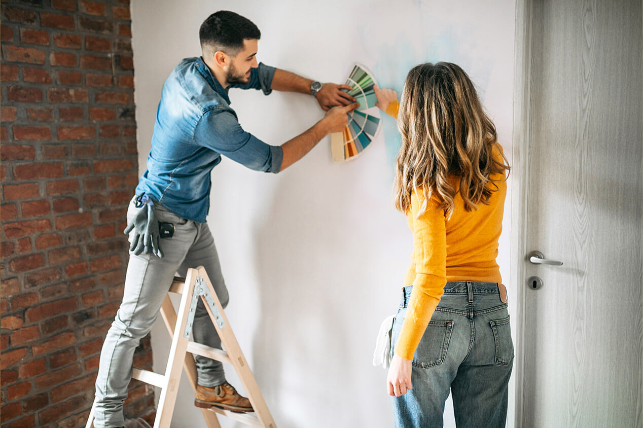 Couple choosing paint colors from a sample wheel