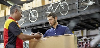 Retail store employee signing for a package delivery