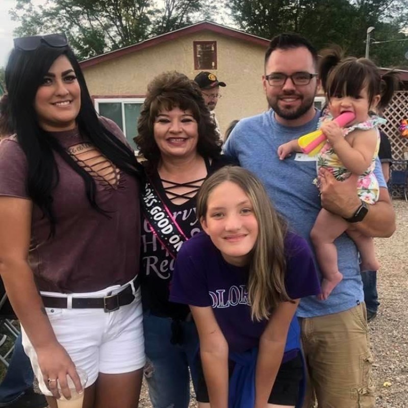 An image of a family standing together smiling for a photo at a get together. 