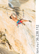 Rock climber holding on with both hands on the rock. Стоковое фото, фотограф Iván Moreno / Фотобанк Лори