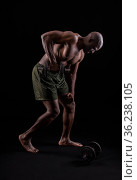 Side view of a muscular man standing leaning forward doing triceps exercise. Стоковое фото, фотограф Iván Moreno / Фотобанк Лори