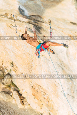 Rock climber holding on with both hands on the rock