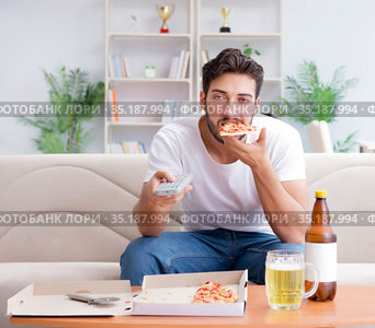 Man eating pizza having a takeaway at home relaxing resting