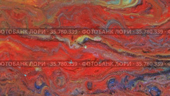 Abstract bright red and light pastel streams flow across the plane on a blue background. Marble texture. Fluid art. Liquid abstractions.