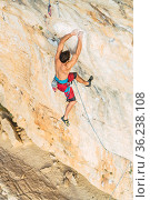 Aerial view from above of the back of a man climbing a rock formation. Стоковое фото, фотограф Iván Moreno / Фотобанк Лори