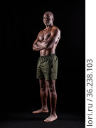 Black man in shorts standing with arms crossed looking at camera seriously. Стоковое фото, фотограф Iván Moreno / Фотобанк Лори