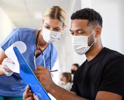 Nurse assisting a patient with paperwork