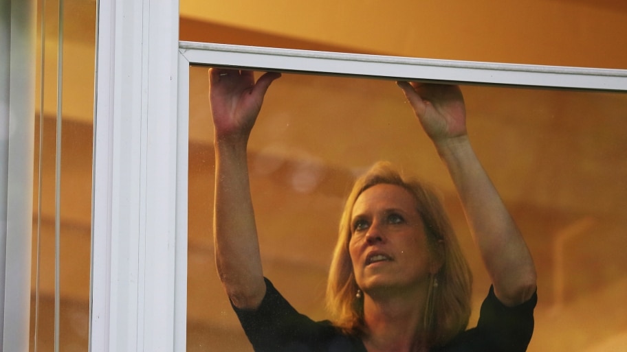 woman adjusting storm windows