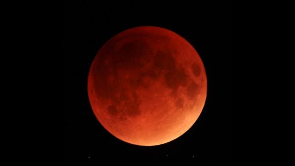 A bright red Moon during a total lunar eclipse against a black night sky.