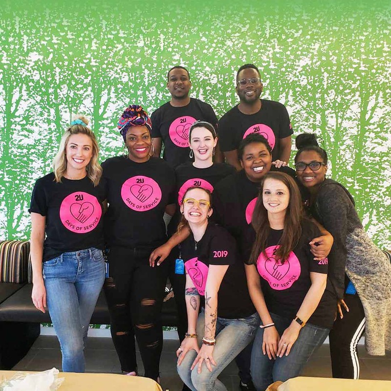 A group of 2U employees pose for a group photo wearing their 2U Days of Service t-shirts