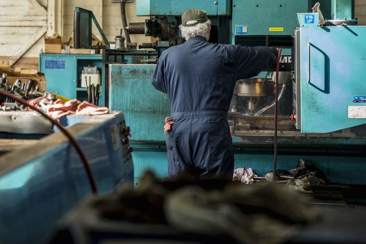 Caucasian man using machinery in metal shop