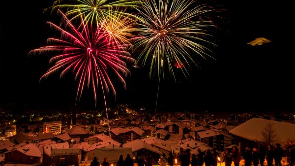 People watching fireworks above a mountain village.