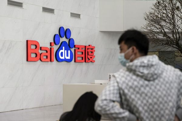 Employees stand in a lobby at the Baidu Inc. headquarters in Beijing.