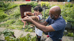 A young grandson helping his grandfather around the garden.