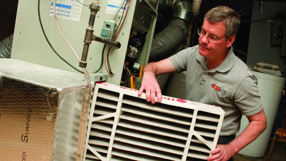 HVAC technician installing furnace air filter