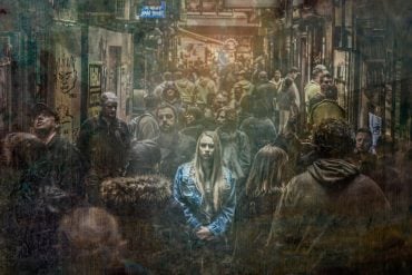 This shows a girl standing alone in a crowd