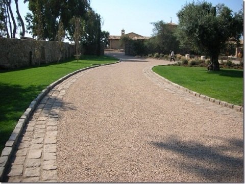 Long chip seal driveway leading to a house