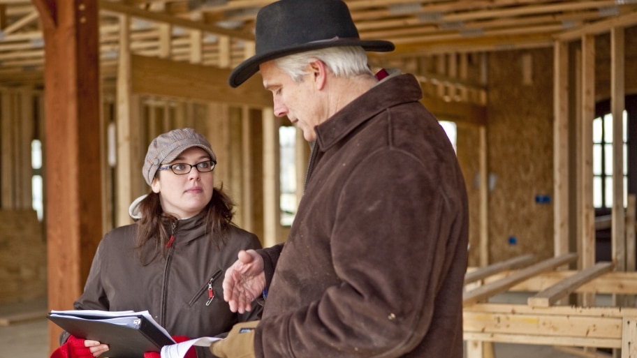 homeowner talks to contractor in unfinished new home