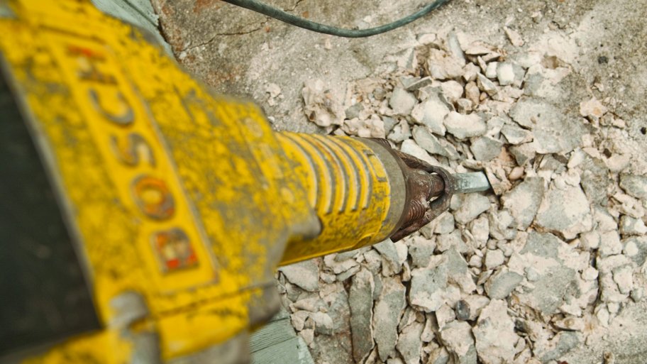 jackhammer busts up concrete foundation