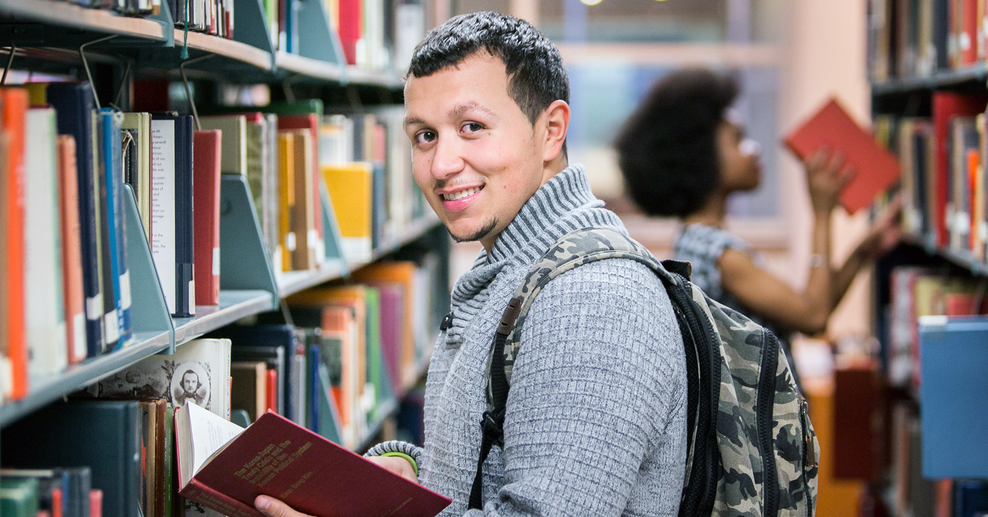 John Jay College student in the library stacks.