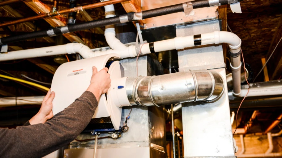 HVAC technician handling an A/C humidifier