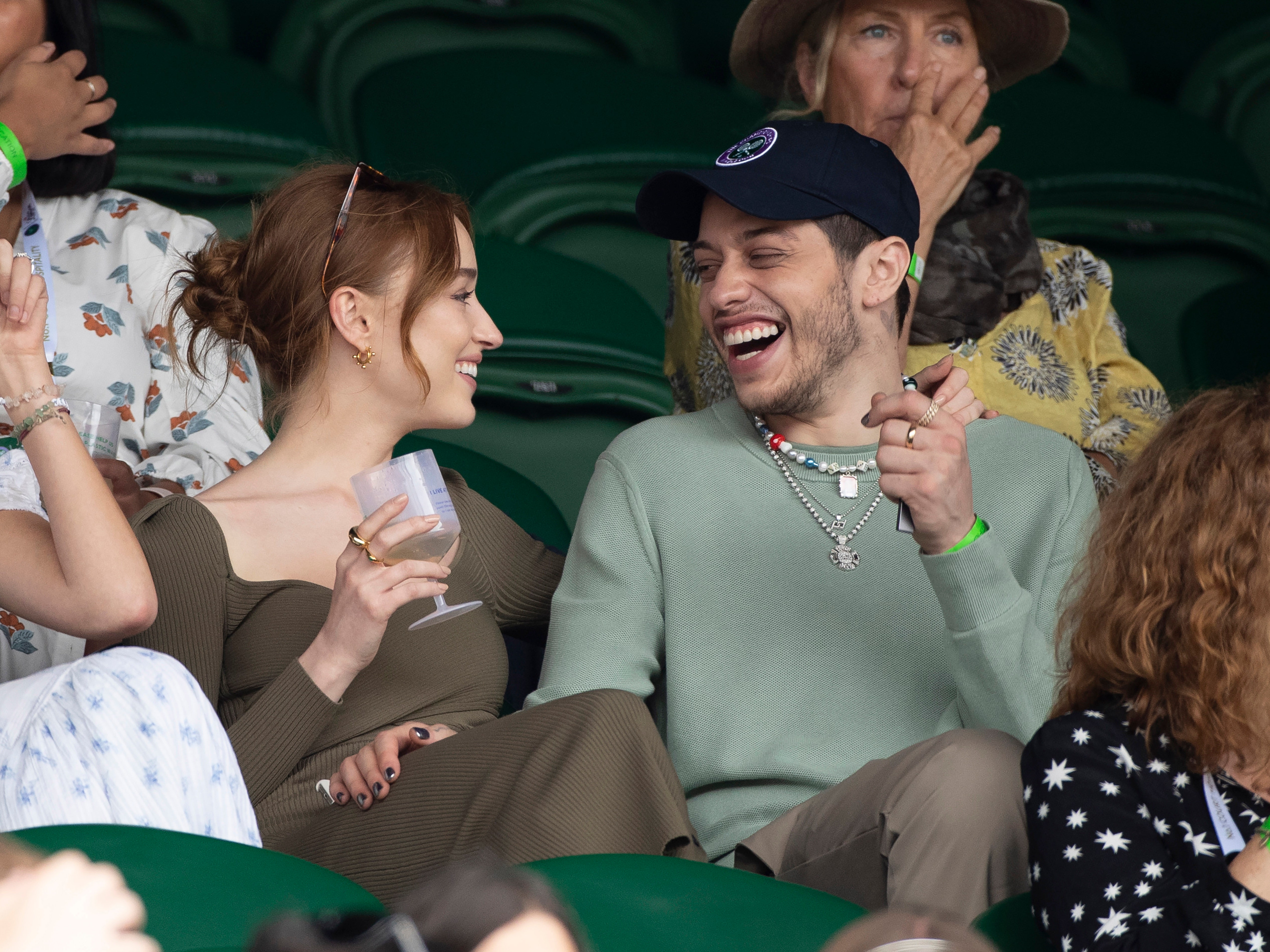 Image may contain Human Person Clothing Apparel Sitting Crowd Audience and Hat