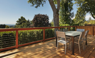 view of wood deck with patio furniture, fence, and green yard in background