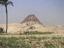 Eroded remains of a pyramid with twin columns marking the entrance to the main complex and causeway leading to it laid before it