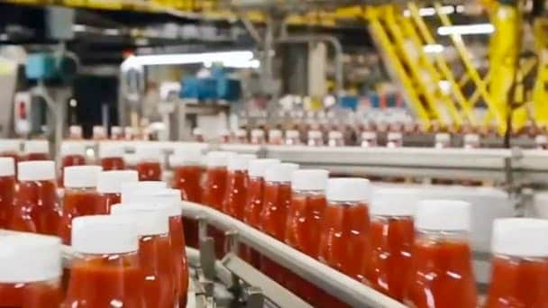 Bottiglia di ketchup su nastro trasportatore