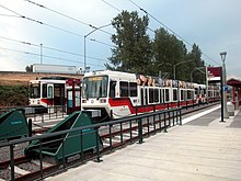 The side platform and an island platform of Expo Center station with two trains waiting