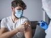 Close up of healthcare frontline worker injecting COVID-19 vaccine to patient.