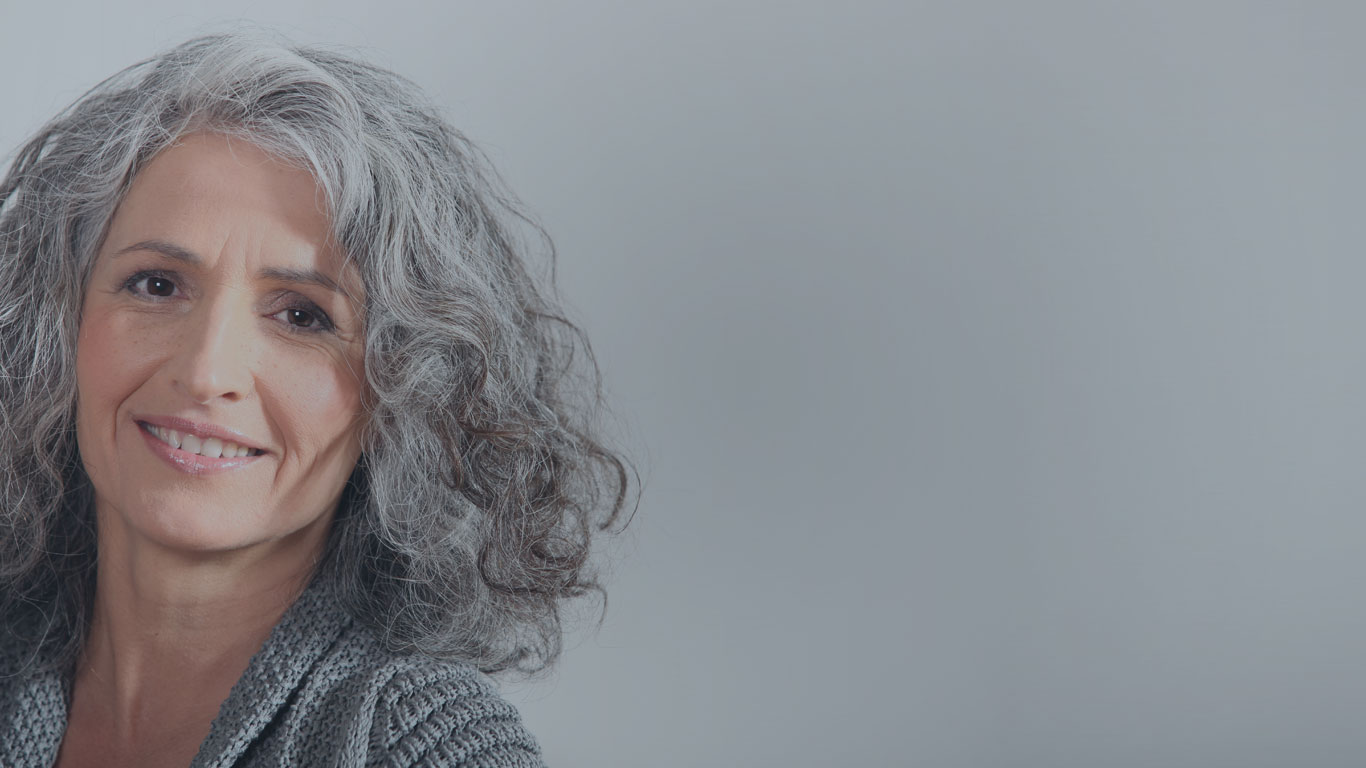 Image of Heffter Home Page Background featuring a gray backdrop and a smiling woman