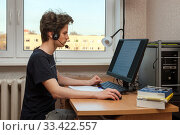 A caucasian teenager studies at home using a PC and headset. Стоковое фото, фотограф Юлия Кузнецова / Фотобанк Лори