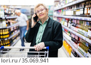 older woman with glasses talking on the phone in the supermarket. Стоковое фото, фотограф Татьяна Яцевич / Фотобанк Лори